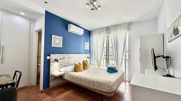 Un dormitorio moderno con cama, escritorio y baño.