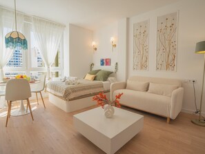 Ein modernes Wohnzimmer mit einer Couch, einem Couchtisch und einem Essbereich mit Stuhl und Tisch.