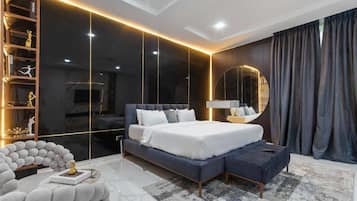 Un dormitorio moderno con una cama grande, un armario empotrado y un espejo redondo.