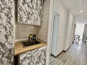 A modern kitchen with marble backsplash, a stainless steel sink, and a wooden countertop. - Newly Renovated Apartment with A/C and WiFi in Central Torremolinos (Torremolinos)