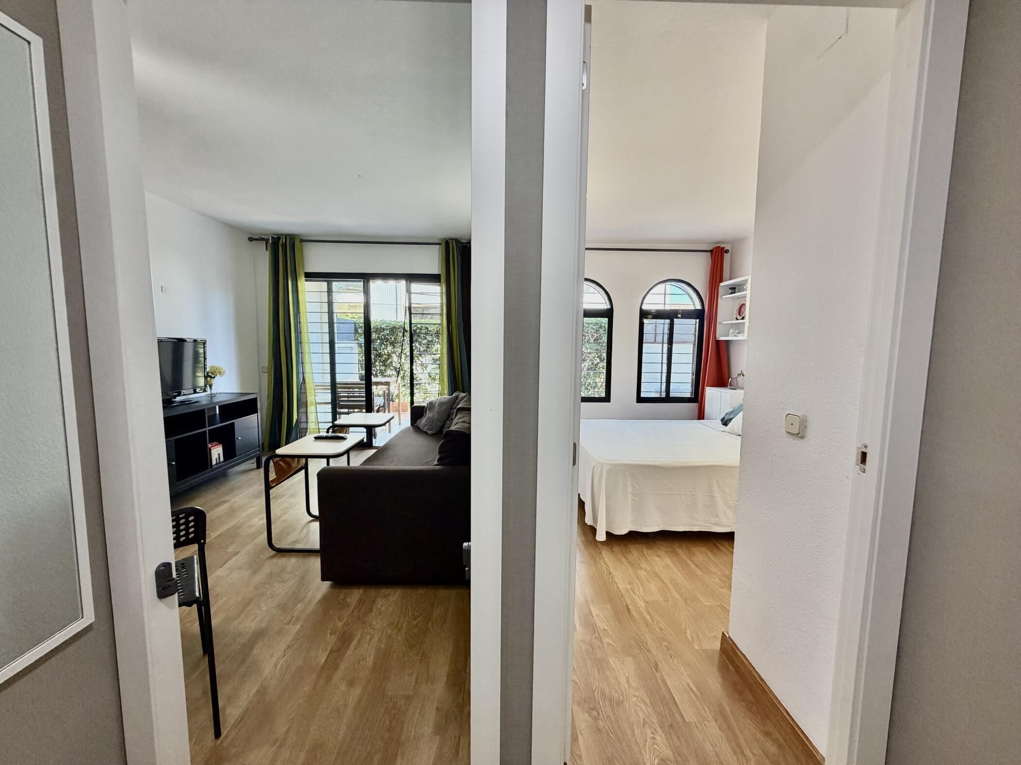 Een kamer met een bed, een bank, een tafeltje en een televisie.