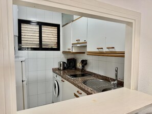 A compact kitchen with a washing machine, a sink, and a window with blinds. - Ground-Floor Apartment with Private Terrace 125 m from the Beach, La Colina (Torremolinos)