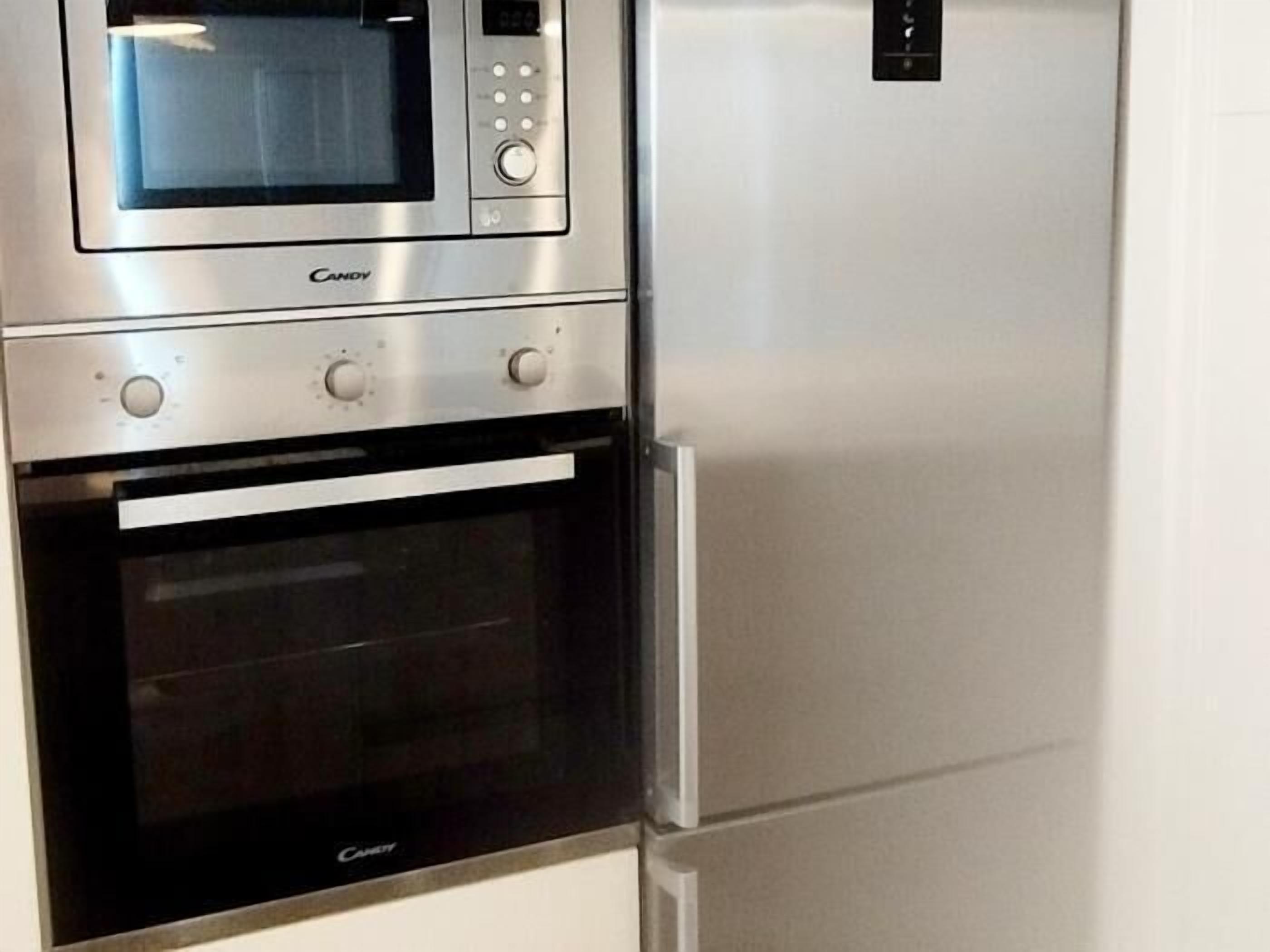Une cuisine équipée d’un four à micro-ondes, d’un four traditionnel et d’un réfrigérateur.