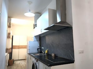 A compact kitchen with a built-in stove, a sink, and a microwave. - Brand-New Studio 130 m from Bajondillo Beach, Torremolinos (Torremolinos)