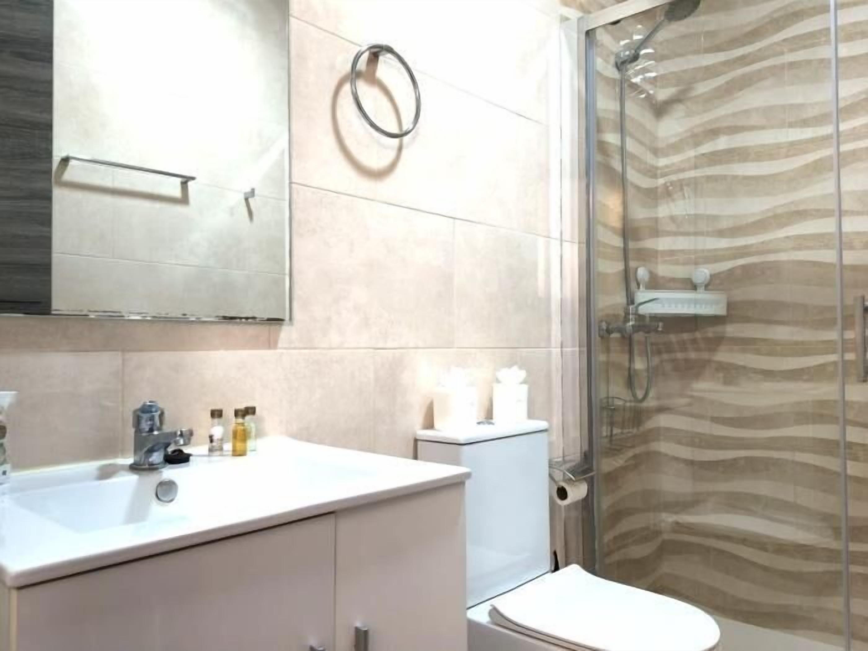 Un bagno con lavandino, WC e doccia.