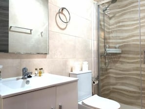 A bathroom with a sink, toilet, and shower. - Brand-New Studio 130 m from Bajondillo Beach, Torremolinos (Torremolinos)