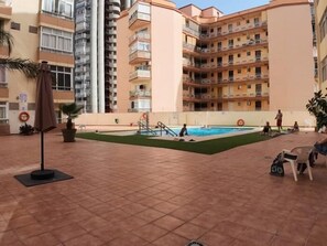 A swimming pool area with tiled flooring, a pool, and a few lounge chairs. - Central Studio with Pool and Lift, 800 m from the Beach, Torremolinos (Torremolinos)