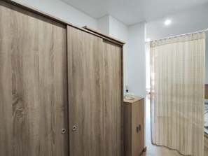A room with a wardrobe, a bedside table, and a curtain. - Renovated Sea-View Studio with Pool and Garden in Torremolinos (Torremolinos)