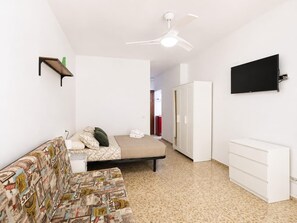 A bedroom with a bed, a white wardrobe, a television mounted on the wall, and a ceiling fan. - Studio with A/C and WiFi in Central Torremolinos, 15 Minutes from the Beach (Torremolinos)