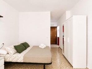 A bedroom with a bed, a bedside table, a wardrobe, and a door leading to another room. - Studio with A/C and WiFi in Central Torremolinos, 15 Minutes from the Beach (Torremolinos)