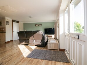 Ein Wohnzimmer mit einer Couch, einem Fernseher und einem kleinen Tisch.