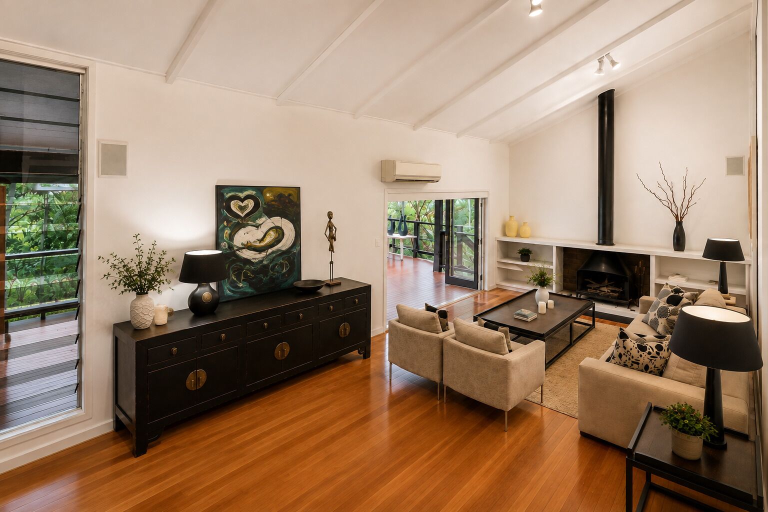 A modern living room with a fireplace, a large painting, and a dining area.