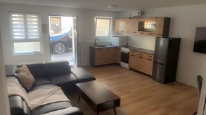 A modern apartment with a living room, kitchenette, and a view of the street. - Arlinda Apartment with Shared Terrace and Wi-Fi (Ettenheim)