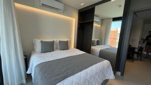 Ein Hotelzimmer mit zwei Betten, einem großen Spiegel und einem Kleiderschrank.