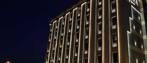A multi-story hotel with illuminated signage, a prominent entrance, and a modern architectural design.