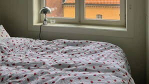 Un dormitorio con una cama, una ventana y una lámpara.