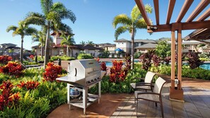 An outdoor patio with a grill, seating, and a pool.