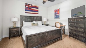 Ein Schlafzimmer mit Bett, Nachttischen, einem Schminktisch und Wandbildern.