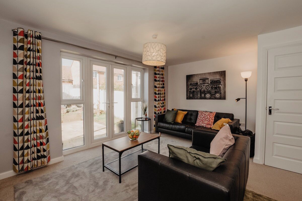A living room with a sofa, coffee table, and a painting on the wall.