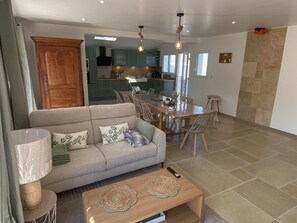 A modern living room with a sofa, coffee table, and dining area. - Villa for 9 people near La Gautrelle Beach, ideally located (Saint-Georges-d'Oléron)