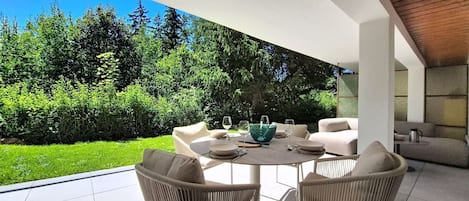 Eine Terrasse im Freien mit einem runden Tisch, zwei Stühlen und einer Schüssel.