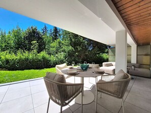 Une terrasse extérieure avec une table ronde, deux chaises et un saladier.
