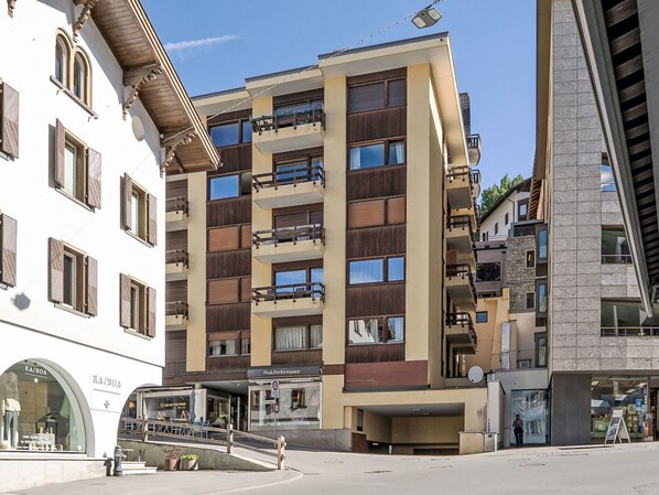 A multi-story building with balconies, a storefront, and a street view. - Beautiful apartment for 4 guests with WIFI, TV, balcony, pets allowed and panoramic view (Saint Moritz)