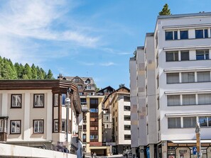 A multi-story building with a mix of residential and commercial spaces, including a visible storefront with a sign. - Beautiful apartment for 4 guests with WIFI, TV, balcony, pets allowed and panoramic view (Saint Moritz)