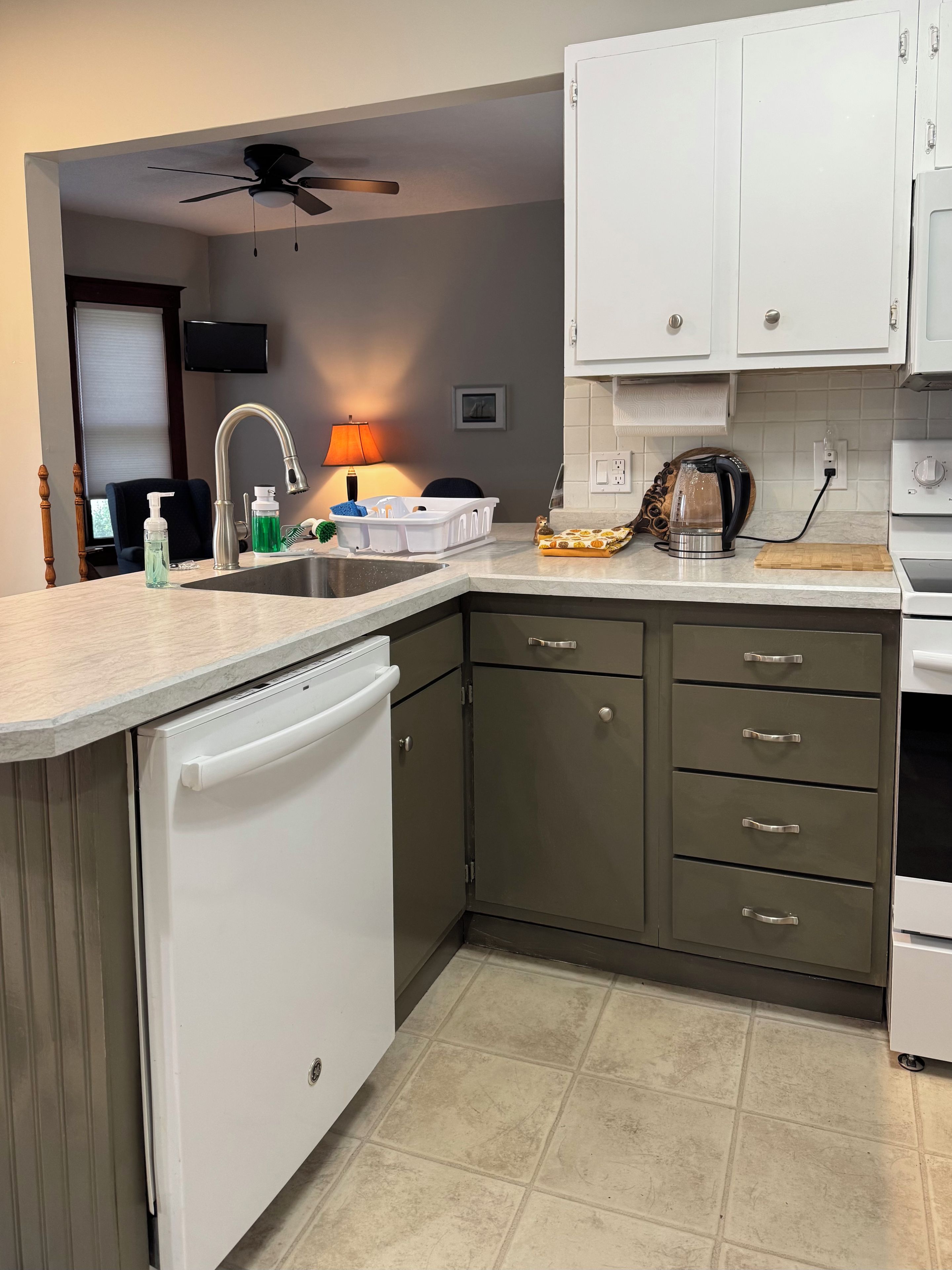 A kitchen with a dishwasher, a coffee maker, and a microwave.