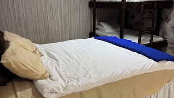 A bunk bed with a white mattress and a beige skirted bed base.