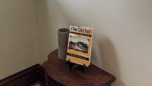 Un livre intitulé « Une ville nommée Perry » est posé sur un présentoir en bois dans une pièce où se trouve un miroir au-dessus.