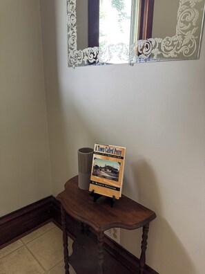 A book titled 'A Town Called Perry' on a wooden stand in a room with a mirror above.