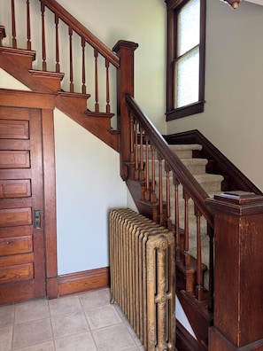 A wooden staircase with a radiator at the bottom.