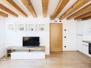 Eine moderne Küche mit weißen Schränken und Holzbalken an der Decke.