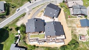 A multi-story residential building with a flat roof, multiple windows, and a visible outdoor deck area. - Santal - Les Gets - Selena Residence (Les Gets)