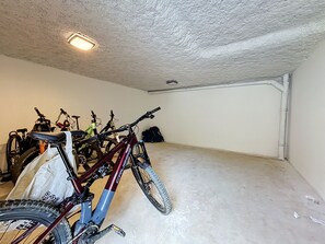 A garage with bicycles parked inside. - Santal - Les Gets - Selena Residence (Les Gets)