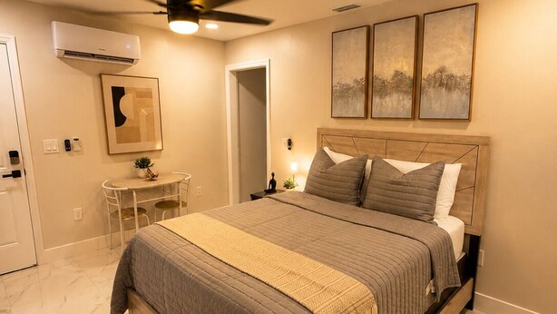 Un dormitorio con cama, escritorio y ventilador de techo.