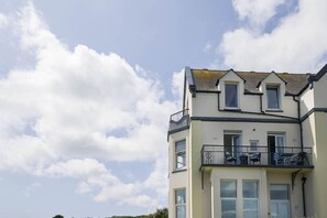 Een meerlaags gebouw met een balkon op de bovenste verdieping.