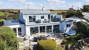 A modern two-story house with a large deck, outdoor seating, and a hot tub. - Fourburrows - sleeps 10 guests in 5 bedrooms (Mawgan Porth)