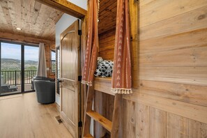 Un intérieur en bois avec une porte coulissante donnant sur un balcon avec vue.