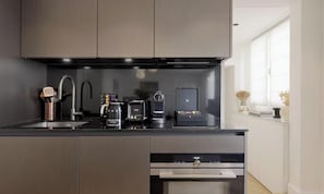 Eine moderne Küche mit integriertem Geschirrspüler, einer Kaffeemaschine und einem Toaster.
