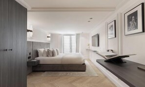 Ein modernes Schlafzimmer mit Bett, Nachttisch und Flachbildfernseher.