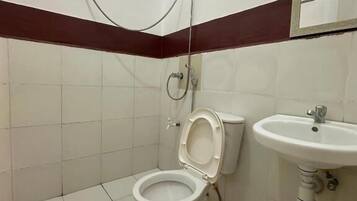 Un baño con inodoro, lavamanos y ducha.