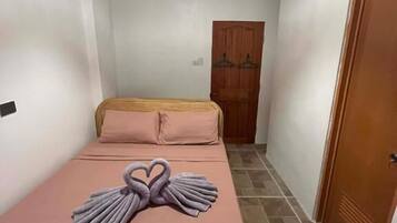 Ein Zimmer mit einem Bett, einer Holztür und einer Chandelier.