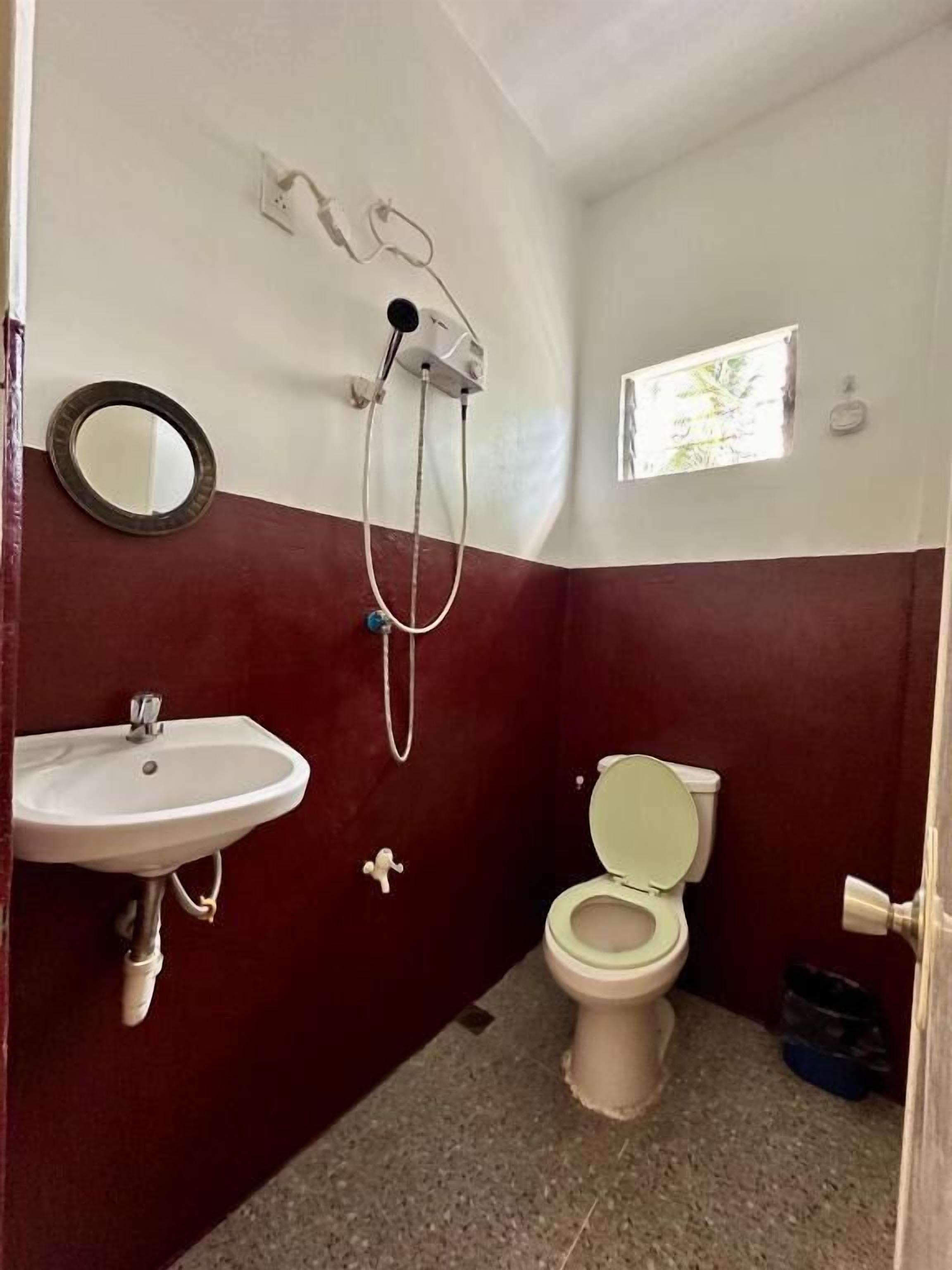 A small bathroom with a sink, toilet, and shower.