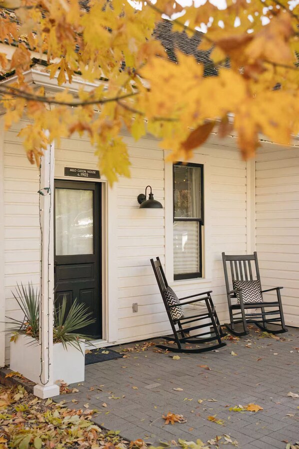 A white house with a black door, two rocking chairs, and a sign reading 'MILO CATON HOUSE c. 1902'. - The Studio - Downtown Jacksonville (Jacksonville)