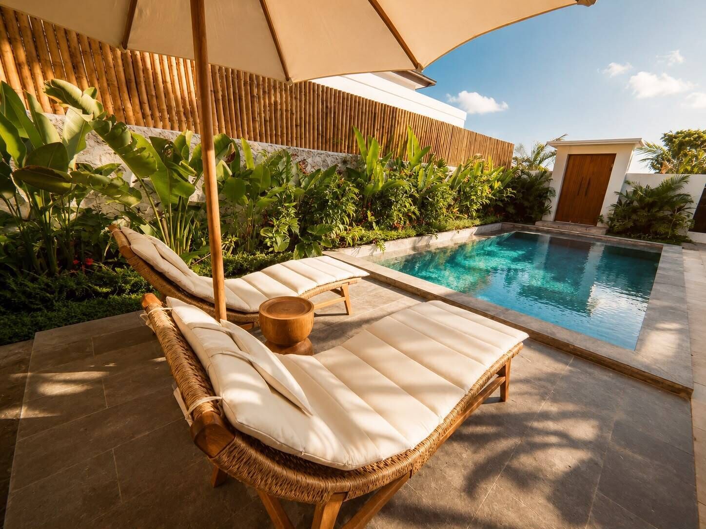 Zona de piscina con sillas de descanso y una valla de madera.