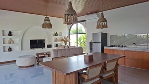 Eine moderne Küche mit einer großen Kochinsel, Holzschränken und einem eingebauten Backofen.