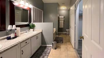 Un baño moderno con tocador, lavamanos y espejo.