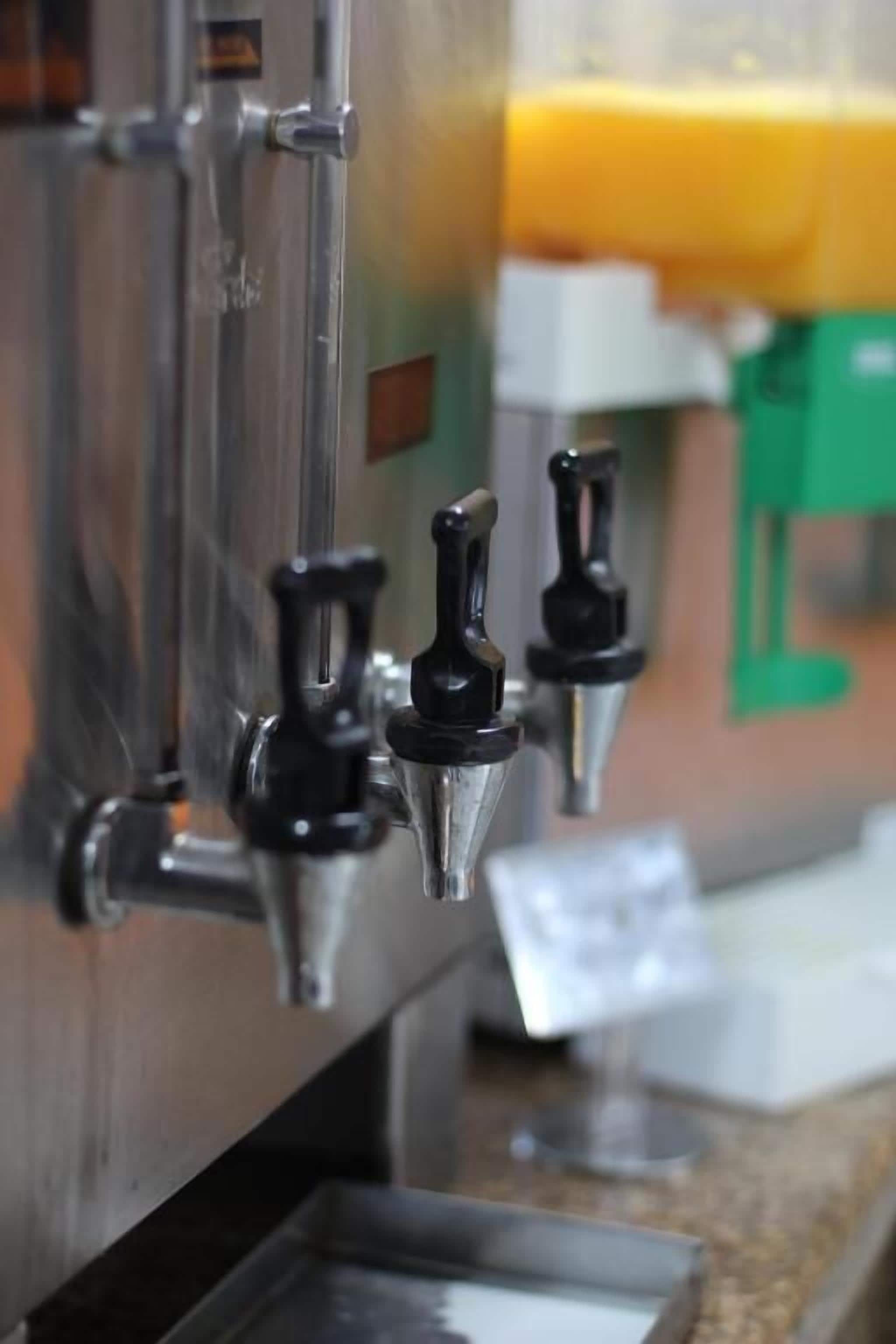 A coffee machine with a metal exterior and a green counter.